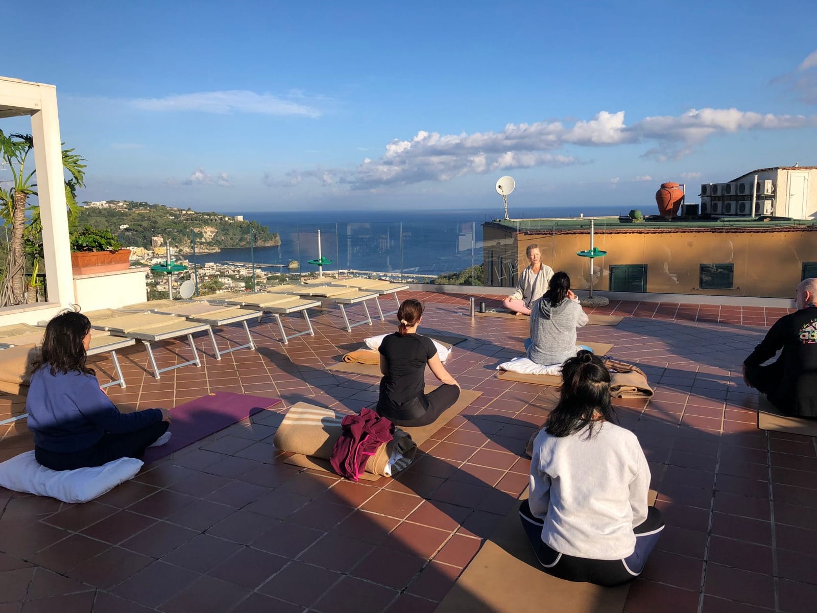 Femmes pratiquant le yoga en groupe sur le toit de l'hotel pour le stage pilates 2026