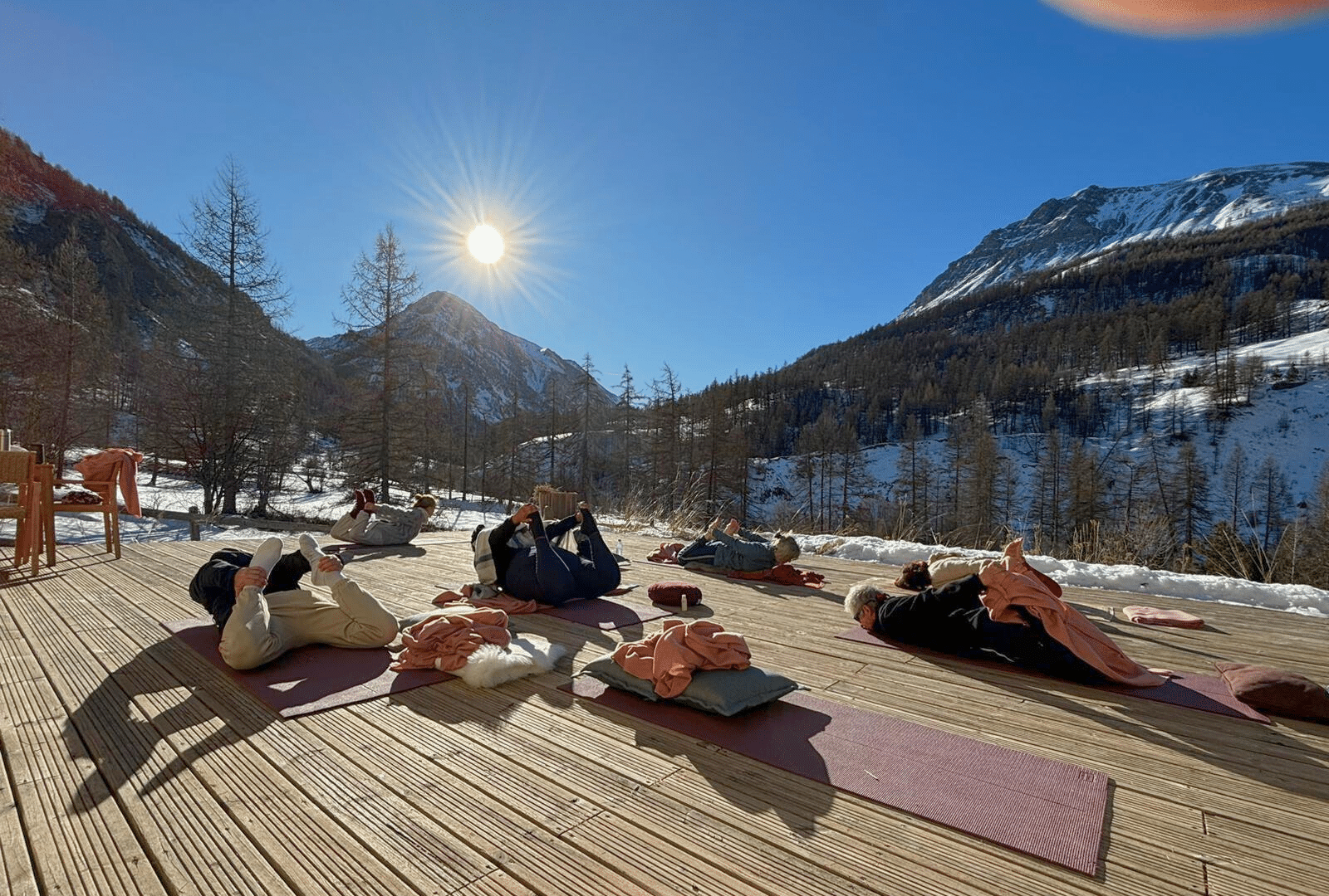 Groupes de personnes pratiquant le yoga au soleil en terrasse lors de la retraite nouvel an