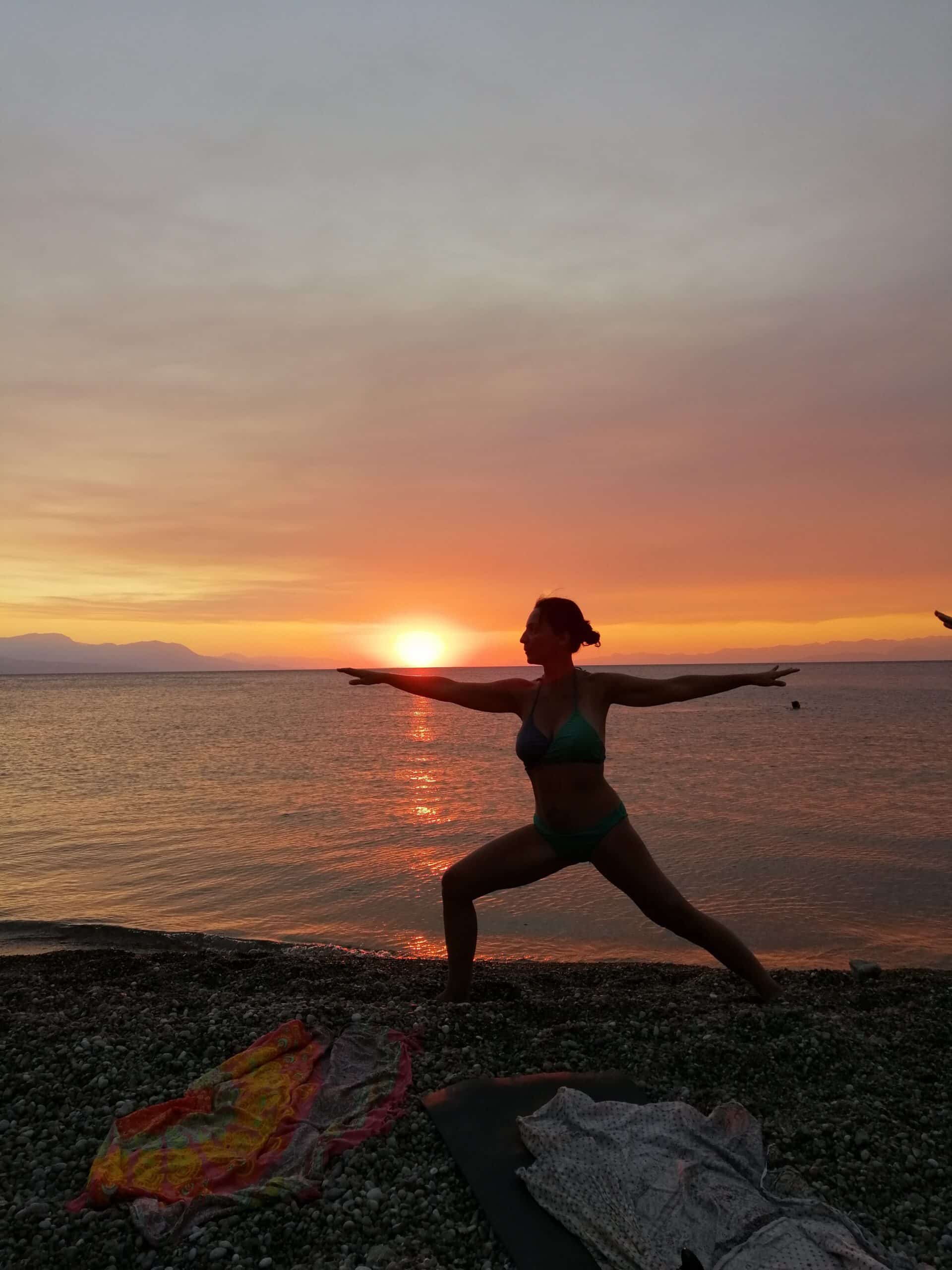 Pratique yoga sur la plage de galet lors de la retraite yoga bord de mer
